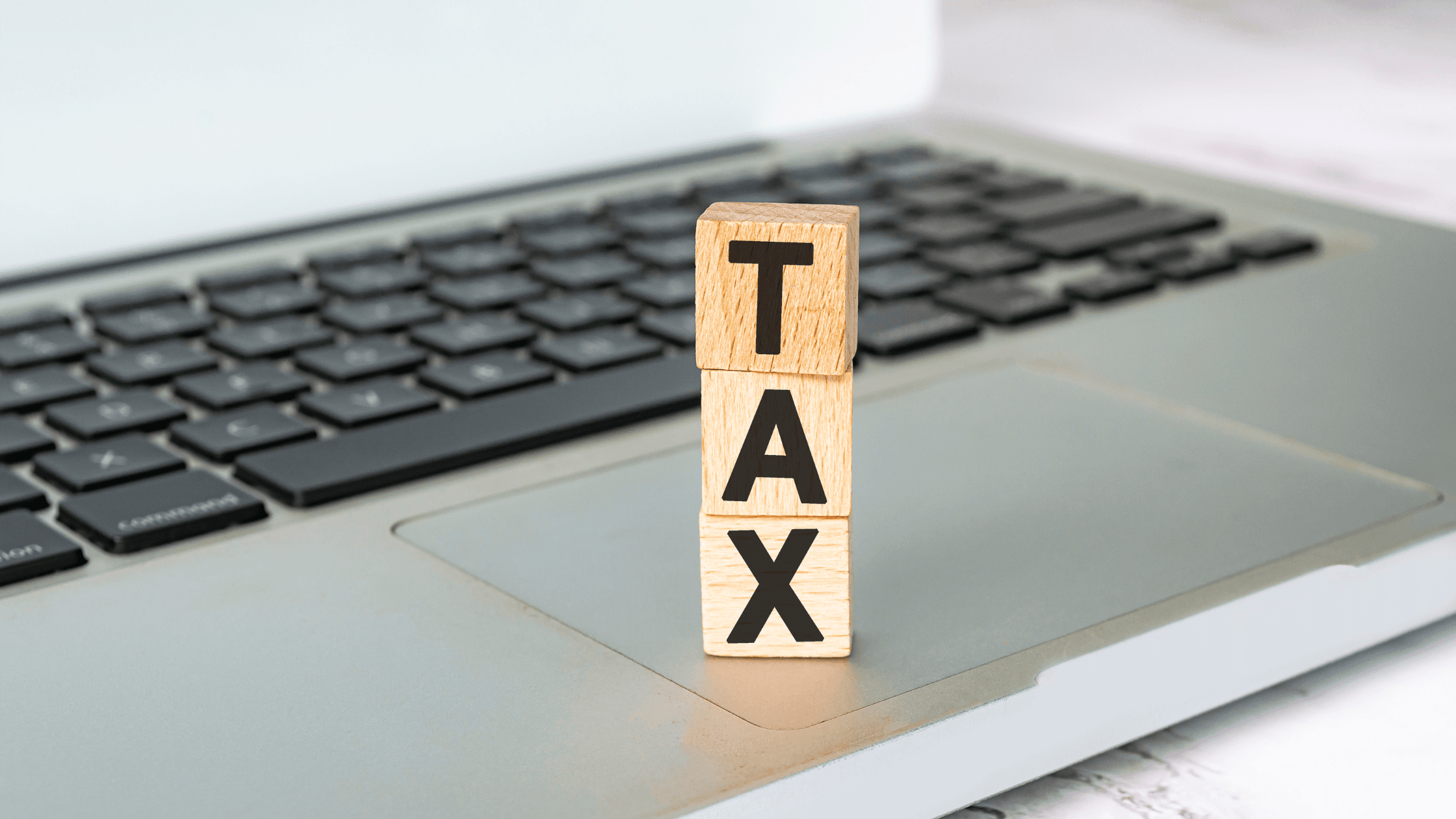 Clavier de PC avec des cubes en bois sur lesquels sont écrit "TAX"