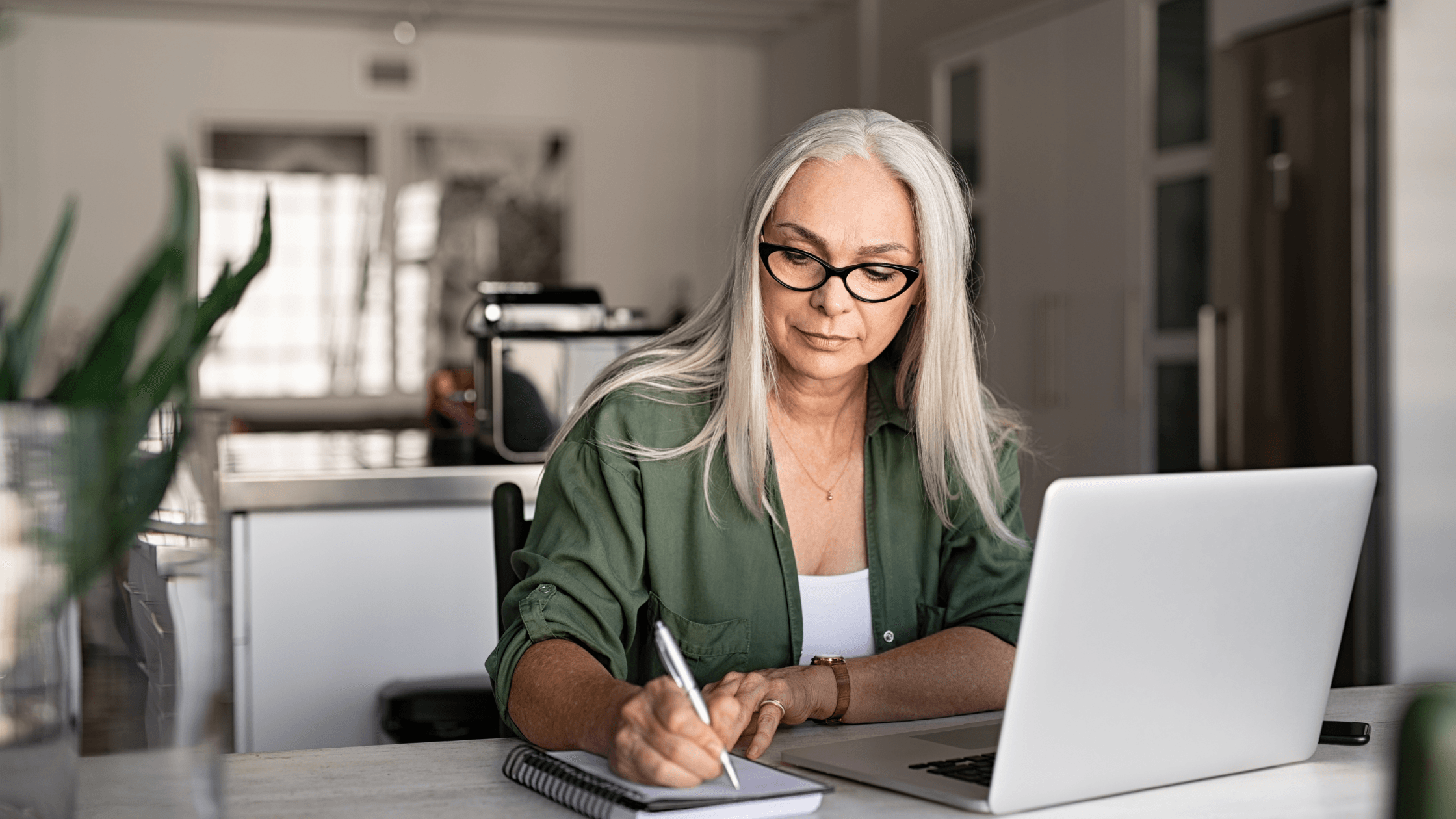 Femme senior avec un PC et un bloc note
