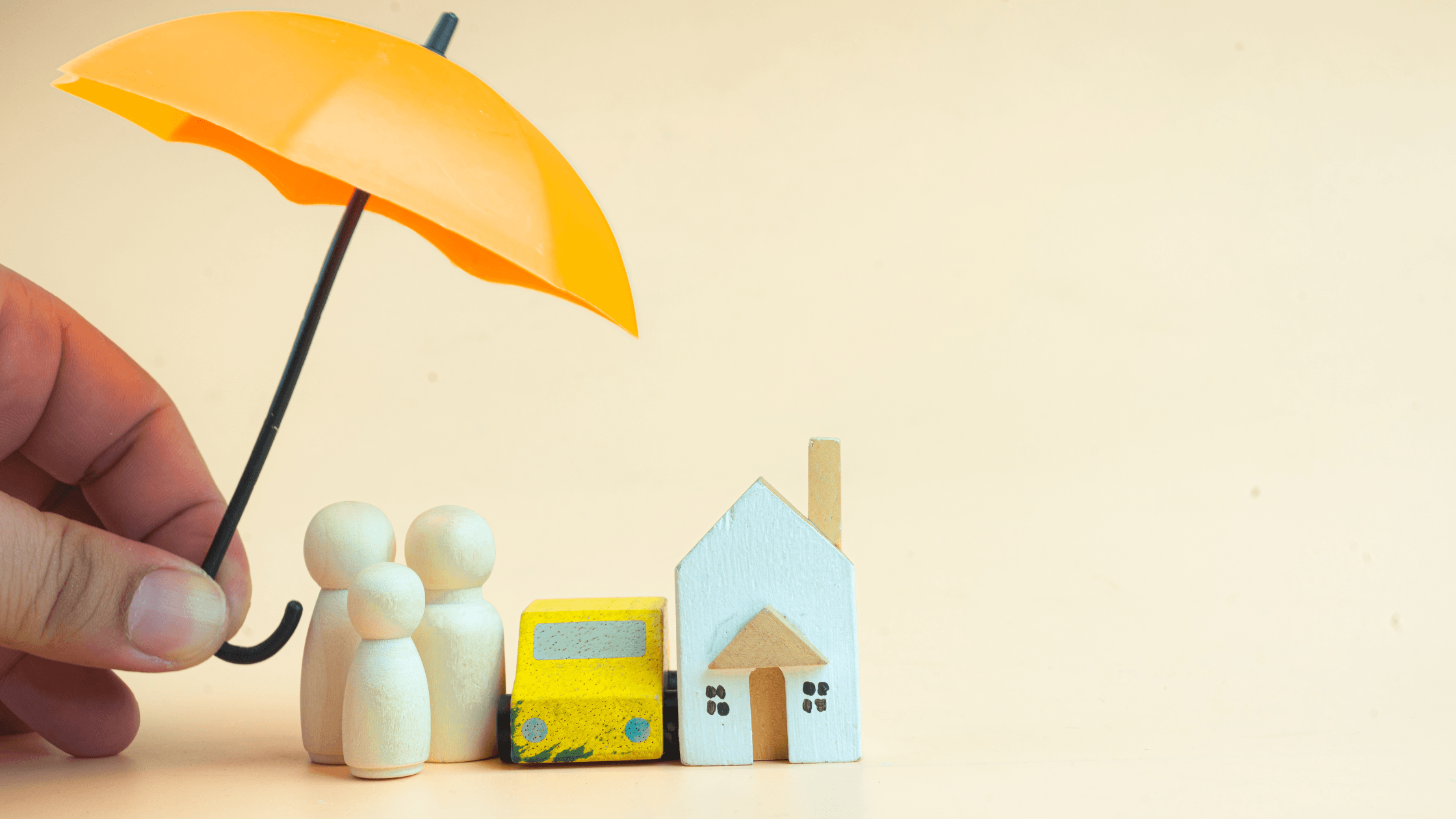 petit modèle en bois 3D d'une maison, une voiture et 3 bonhomme avec un parapluie jaune au dessus